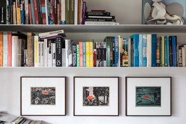 A bookshelf in Fernanda Feitosa's São Paulo home with framed photographs under it 