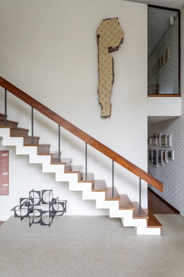 Wooden stairs and a beige structure on the wall in the São Paulo home of Fernanda Feitosa