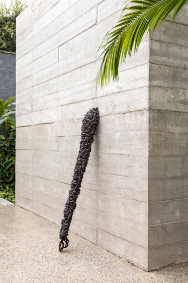 A piece of artwork that resembles a scepter leaned against a wall of Fernanda Feitosa's São Paulo ho...