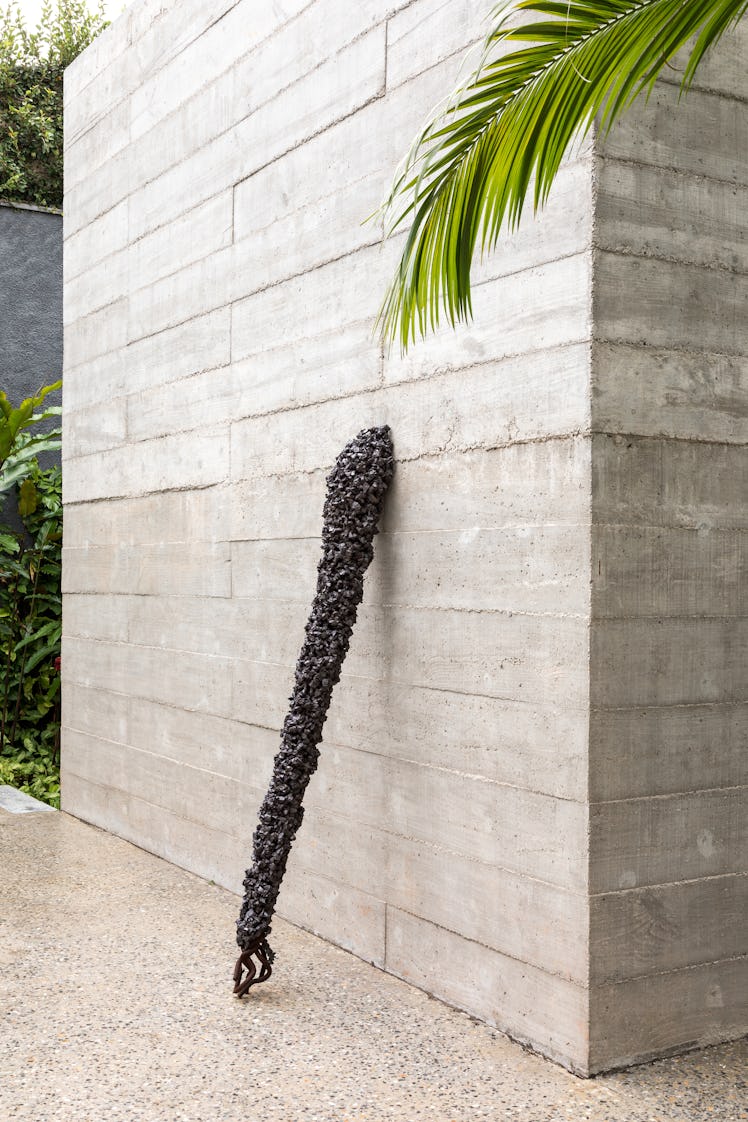A piece of artwork that resembles a scepter leaned against a wall of Fernanda Feitosa's São Paulo ho...