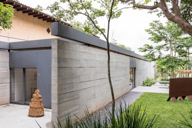 A side entrance to Fernanda Feitosa's São Paulo home with a wooden sculpture in front of it 