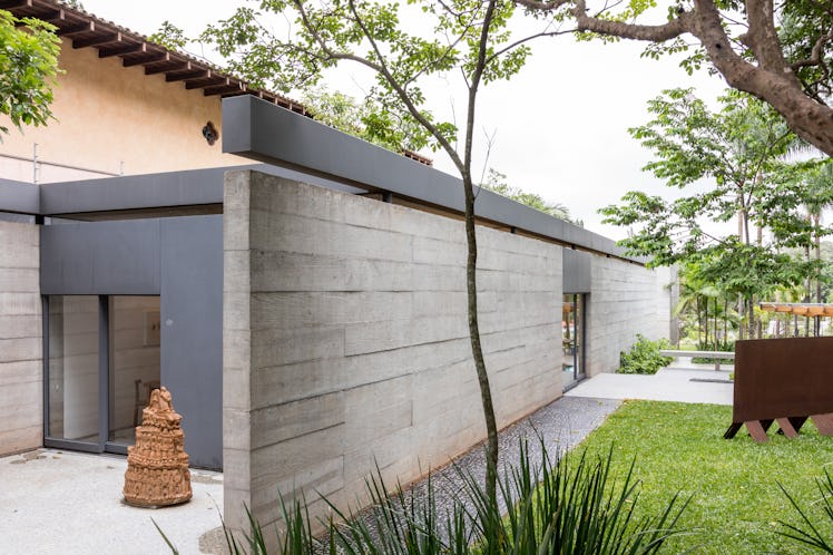 A side entrance to Fernanda Feitosa's São Paulo home with a wooden sculpture in front of it 