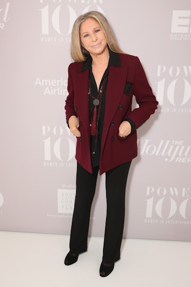 Barbra Streisand in a burgundy blazer, black shirt and black trousers at a red carpet event