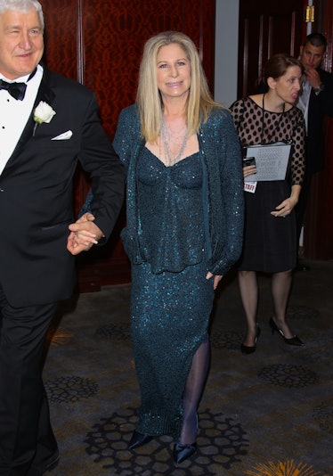 Barbra Streisand in a matching sequin teal top, jacket and skirt at a red carpet event
