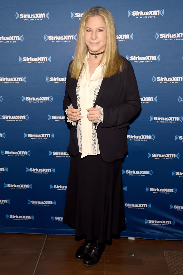 Barbra Streisand in a white shirt, black cardigan and a black skirt at a red carpet event