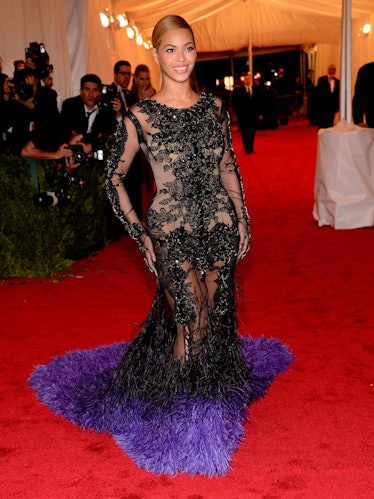 Beyoncé in a black gown with purple feathers at the Met Gala