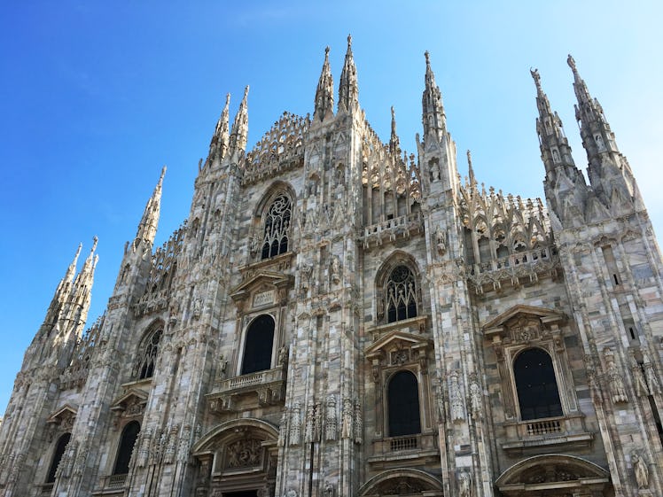 A front view of the Duomo cathedral in Milan and blue sky