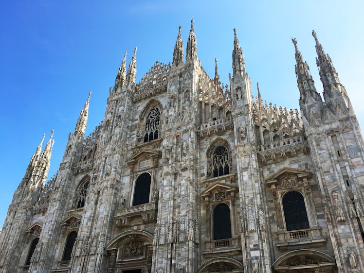 A front view of the Duomo cathedral in Milan and blue sky