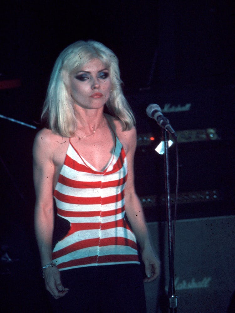 Debbie Harry performing in a white-red striped top and a black skirt