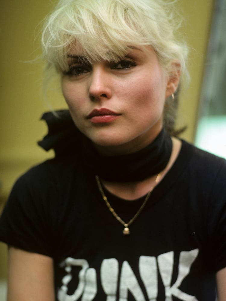 Debbie Harry in a black T-shirt with the print 'PUNK', a black neck scarf and a golden necklace