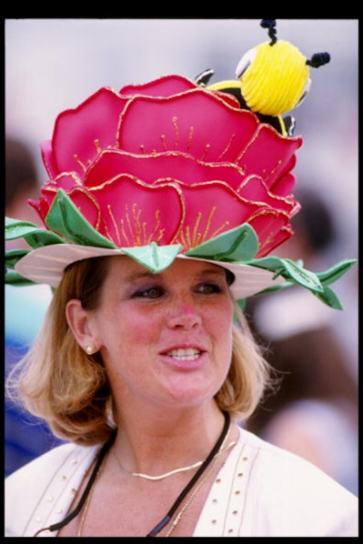 A woman smiling in a white top and a large pink flower hat with a bee at the Kentucky Derby in 1993.