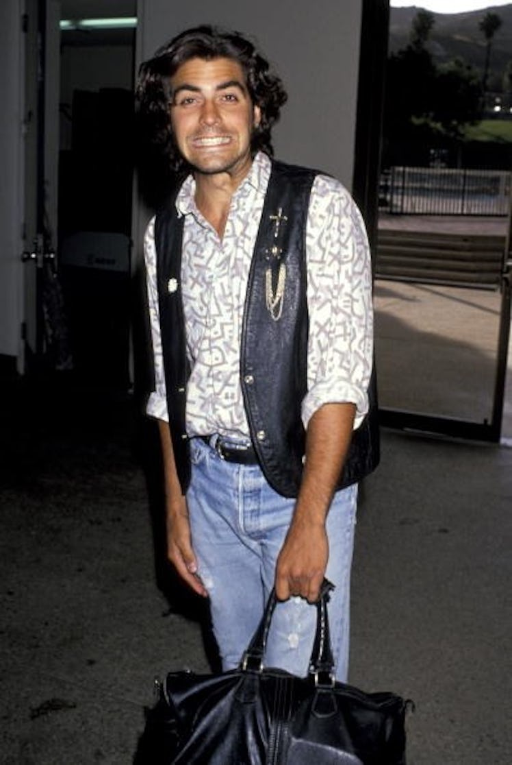 George Clooney with long hair and a black leather vest