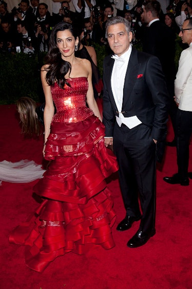 George Clooney in a black and white tux, Amal in a red gown
