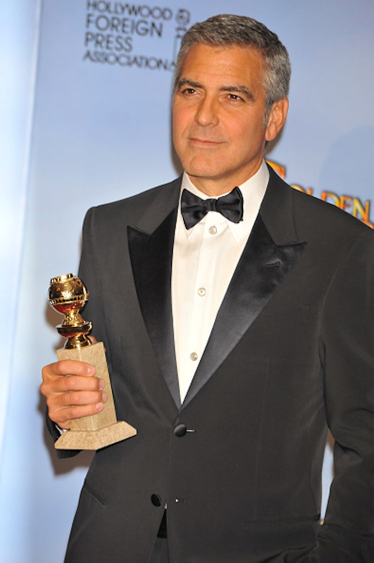 George in a tux holding his Golden Globe