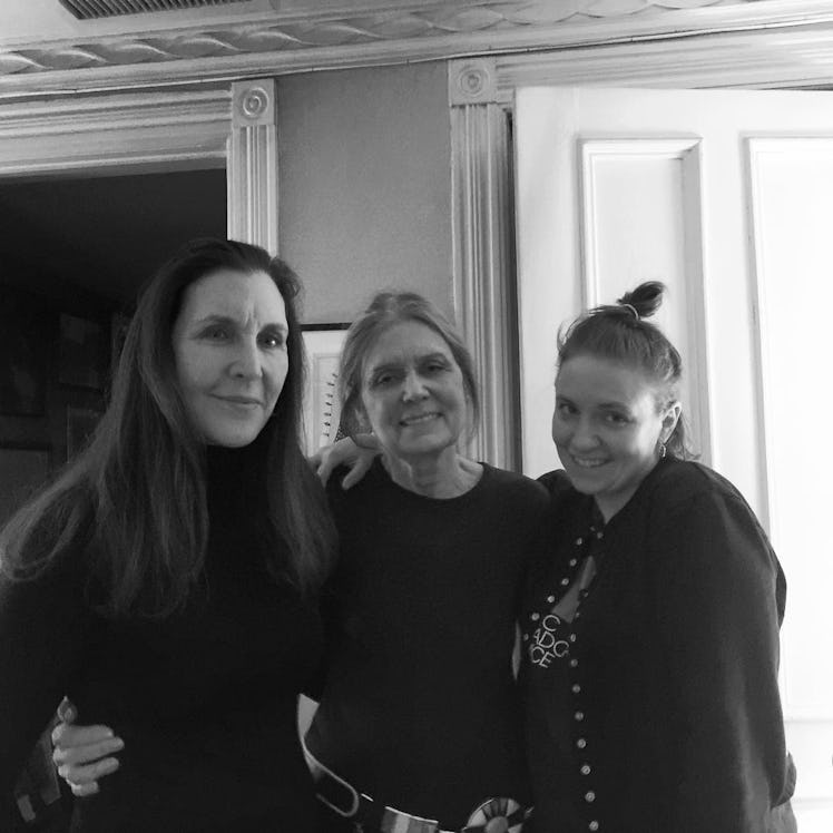 Laurie Simmons, standing and posing with Gloria Steinem and Lena Dunham while smiling