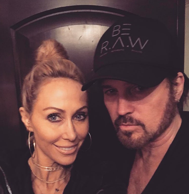 Tish Cyrus in a black hoodie next to Billy Ray Cyrus and posing for a selfie