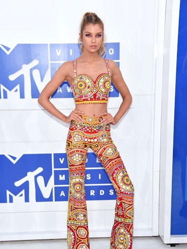 Stella Maxwell posing in a crop top and matching pants by Jeremy Scott at the 2016 MTV Video Music A...