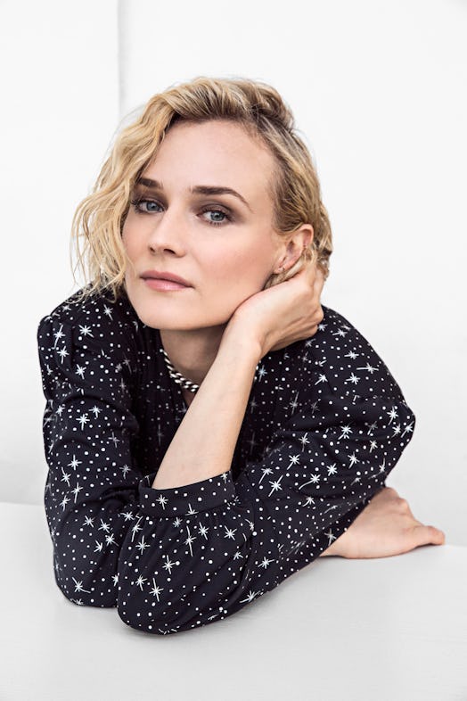 A portrait of Diane Kruger posing in a black dress with white star print at the Cannes Film Festival...