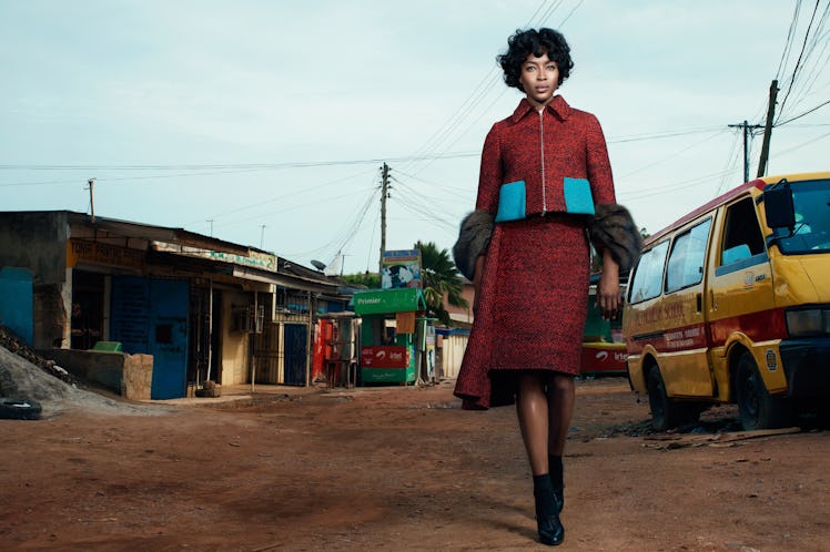 Naomi Campbell walking in Ghana while wearing a burgundy set with bright blue pockets