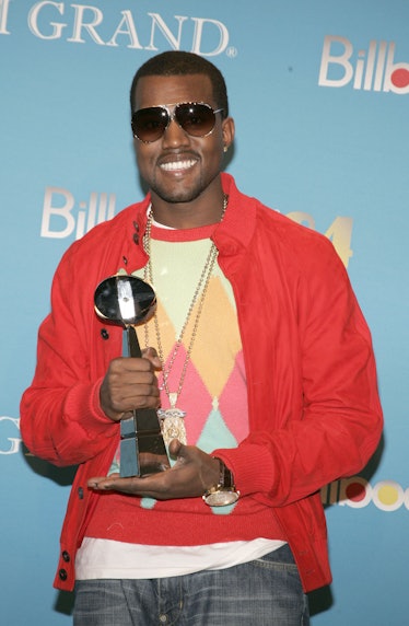 Kanye West in a patterned sweater, red bomber jacket, and aviator sunglasses at the Billboard Music ...