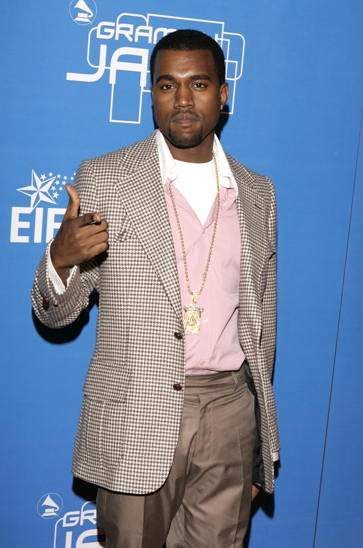 Kanye West in a a light brown suit over a pink sweater at an event in 2004