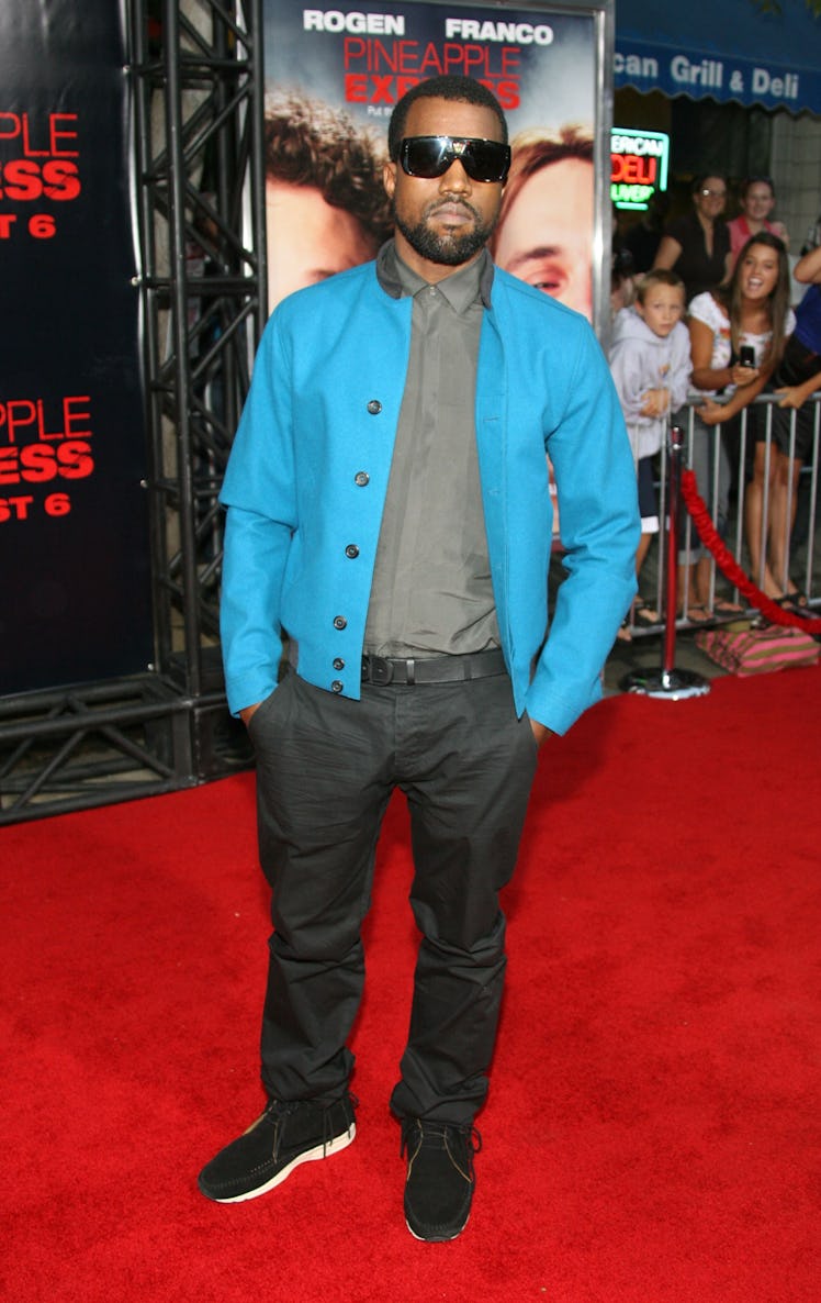 Kanye West in a grey shirt, blue jacket and grey pants at a red carpet event in 2008