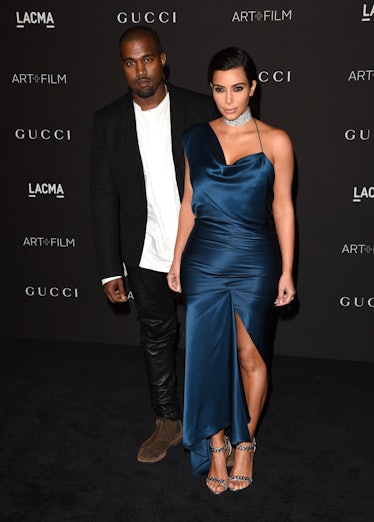 Kanye West in a white shirt, black blazer and trousers and Kim Kardashian in a blue satin dress at a...