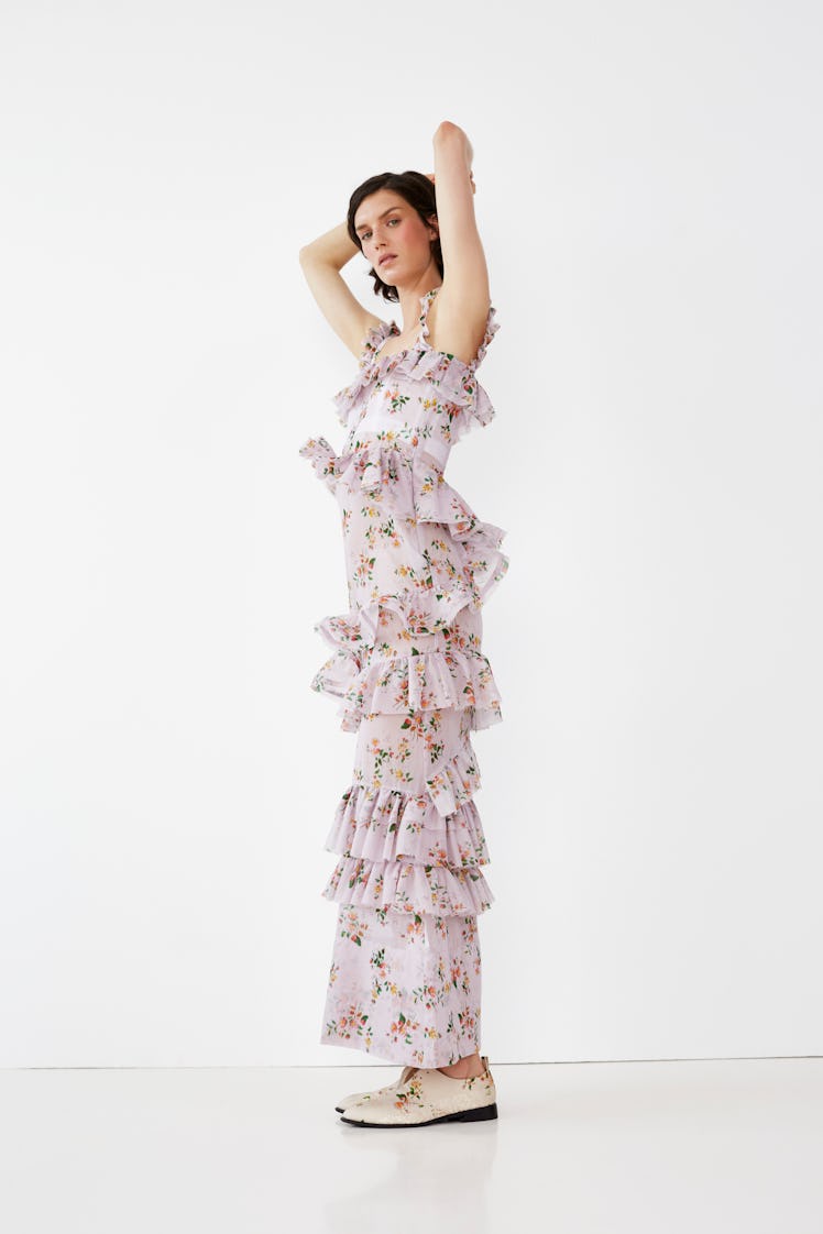 A female model posing in a white tiered floral dress