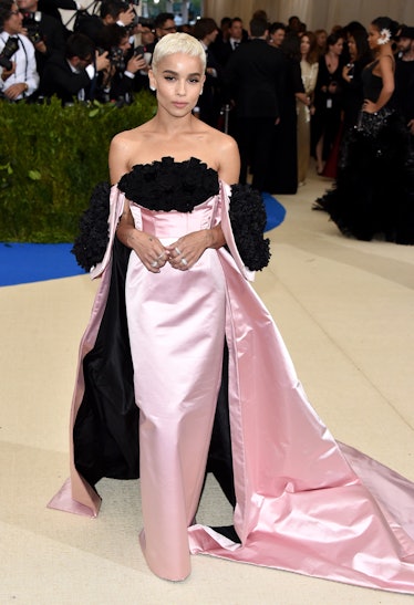 Zoe Kravitz in a pink gown with a matching cape that has black on the inside and around the sleeves