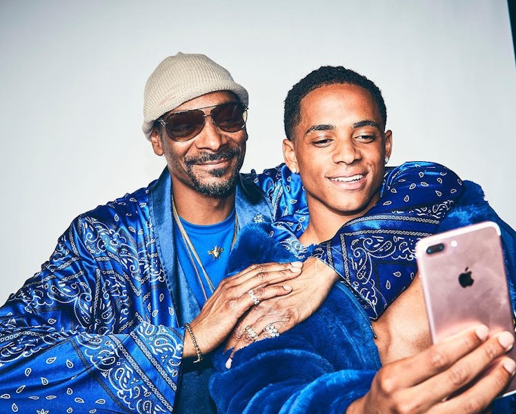 An Instagram post with Snoop Dogg and his son Cordell Broadus sitting and posing together in blue cl...