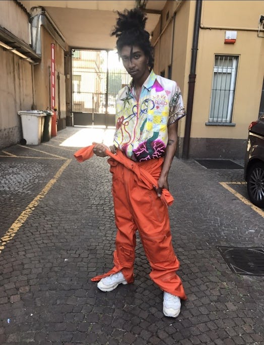 A model wearing a multi-colored shirt with graffiti print and orange trousers by Bad Deal