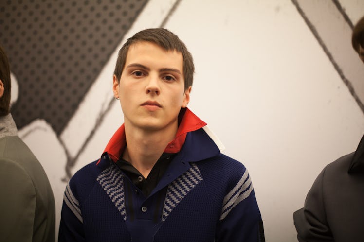 A portrait of a model in a red shirt and a navy-grey jacket at the Prada Spring/Summer 2017 show