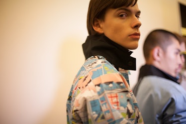 A brunette model in a comic-print jacket and black collar at the Prada Spring/Summer 2017 show