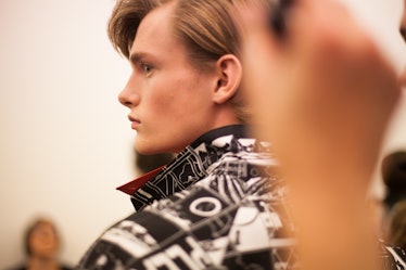 A side-profile of a model in a black-white comic print jacket at the Prada Spring/Summer 2017 show