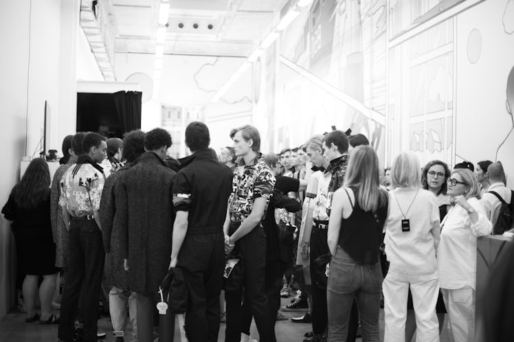 A large crowd of people including models gathering backstage at the Prada Spring/Summer 2017 show