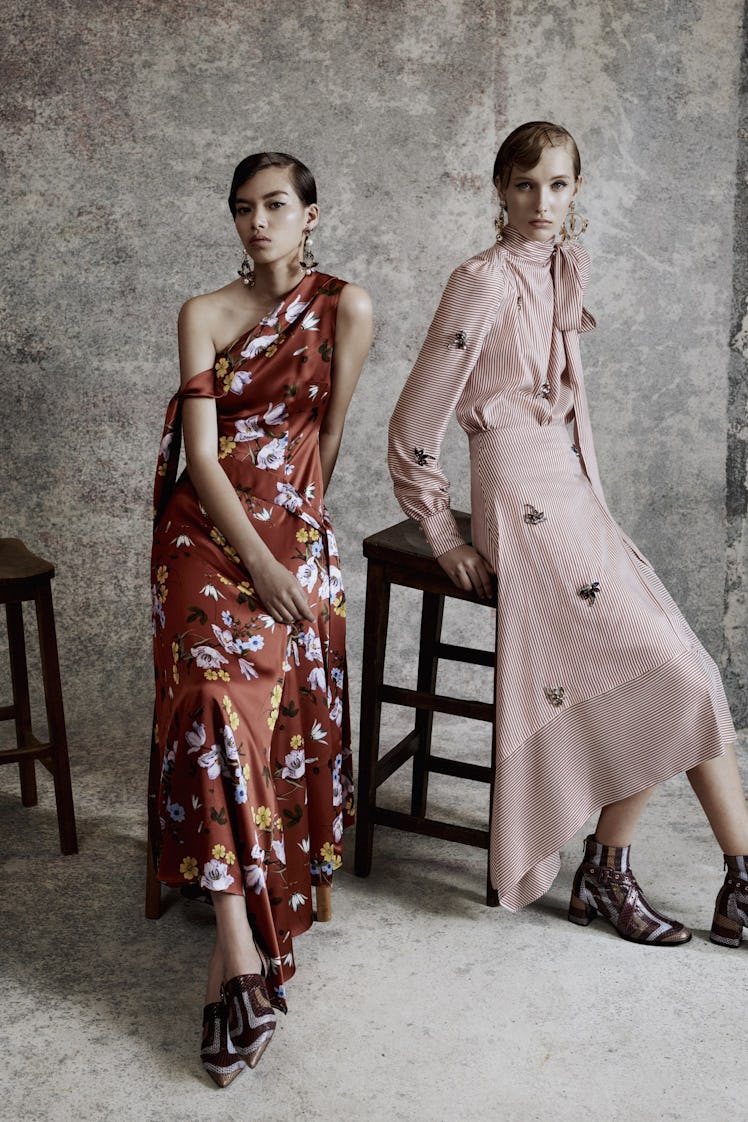 Two female models posing in floral printed burgundy and pink dresses 