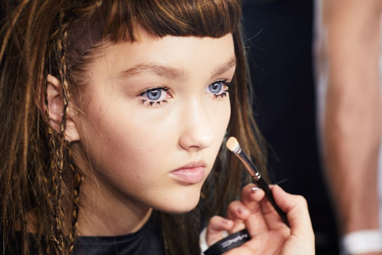 A model getting her makeup done backstage at Iris Van Herpen's 10th Anniversary Fashion Show