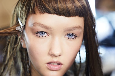 A close-up portrait of a brunette model backstage at Iris Van Herpen's 10th Anniversary Fashion Show