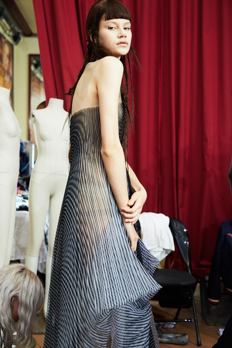 A model in a grey iridescent dress backstage at Iris Van Herpen's 10th Anniversary Fashion Show