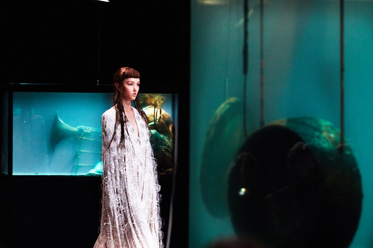 A model in a white dress walking at Iris Van Herpen's 10th Anniversary Fashion Show 