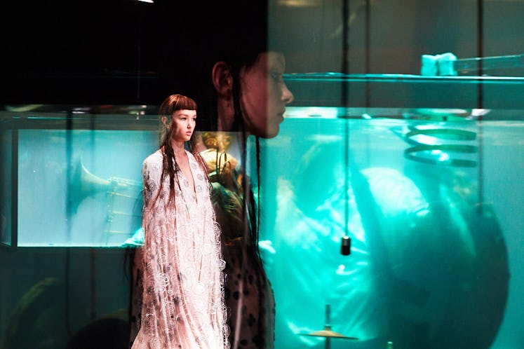 A model walking in a white dress at Iris van Herpen's 10th Anniversary Fashion Show