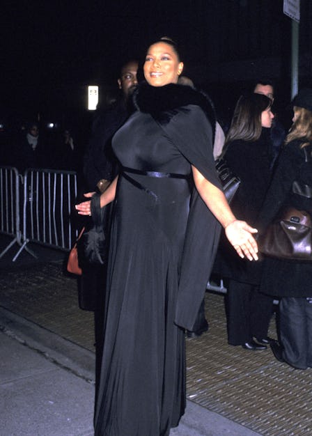 Queen Latifah posing in a long black gown featuring a fur collar