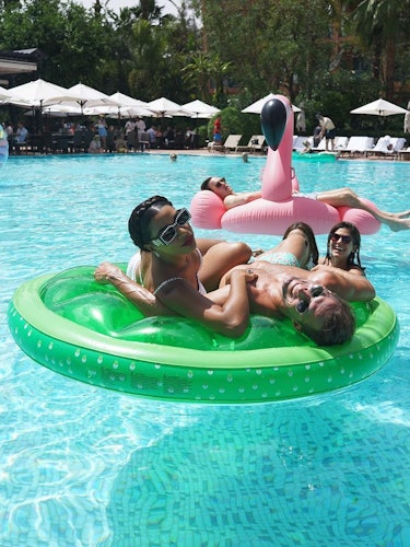 Brendan Fallis and Hannah Bronfman in crystal blue pool water and a bright green inflatable lime.