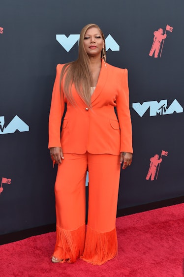 Queen Latifah posing in an orange suit at the 2019 MTV Video Music Awards red carpet