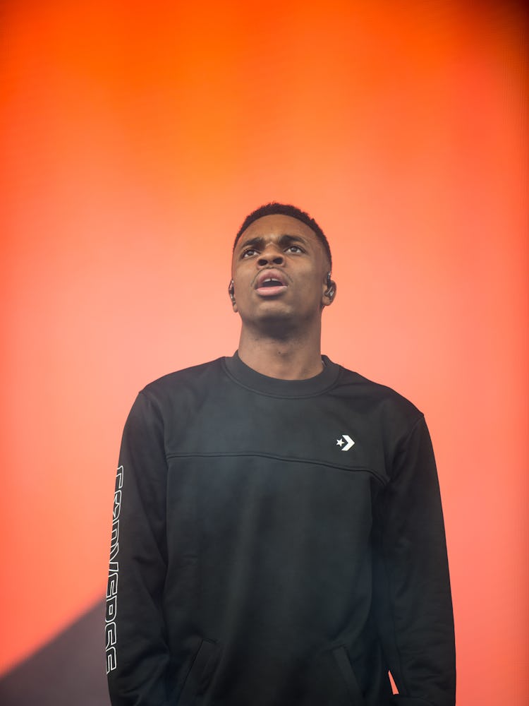 A man in a black sweatshirt in front of an orange wall at the Pitchfork Music Festival