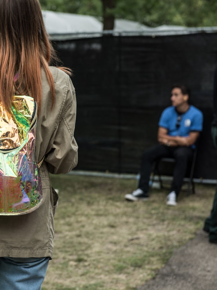 The back of a brunette woman in a grey jacket and a man in a blue shirt at the Pitchfork Music Festi...