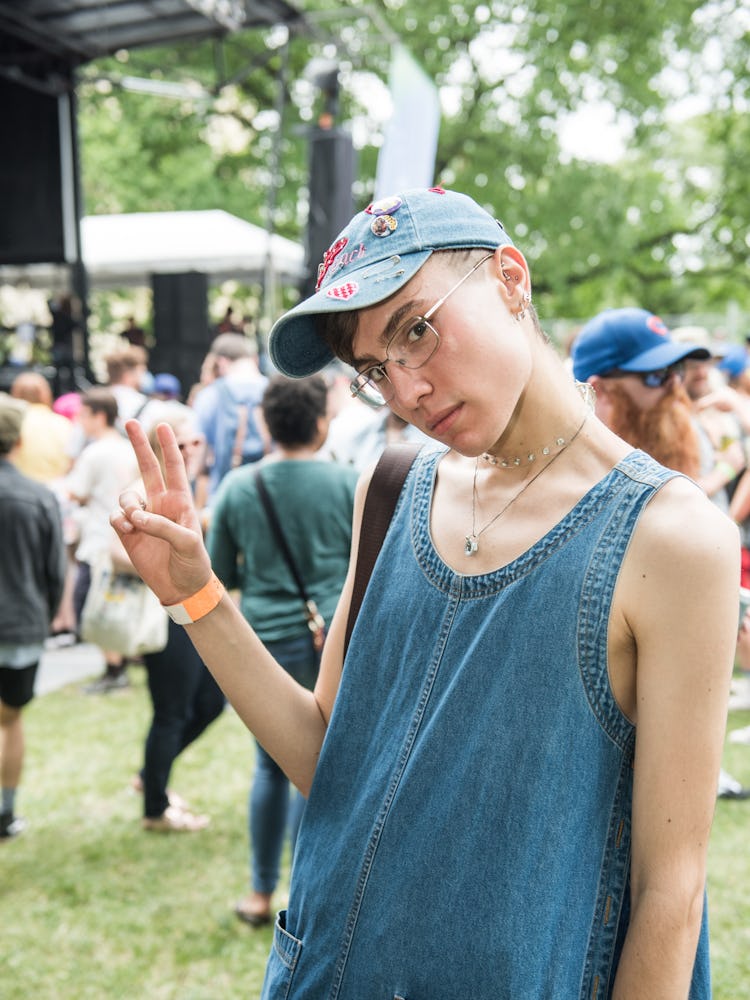 An attendee in a blue denim dress and cap at the Pitchfork Music Festival