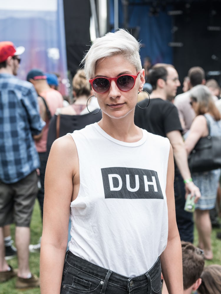 A woman in a white tank top with the text 'DUH' at the Pitchfork Music Festival