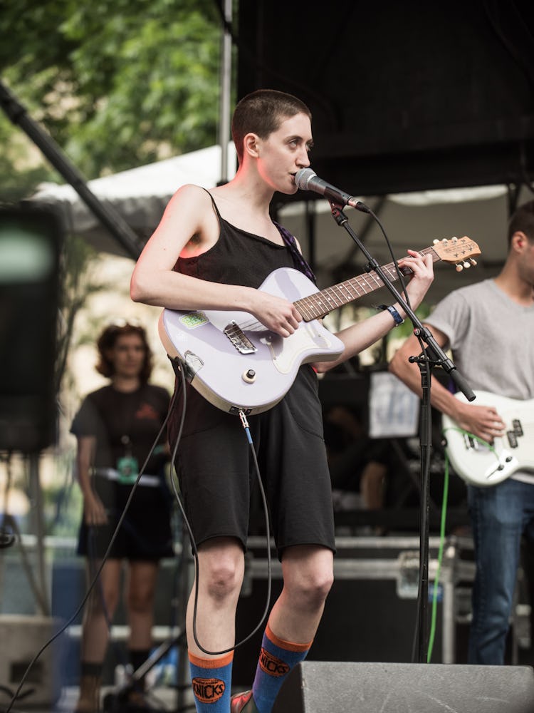 Frankie Cosmos in a black dress with a guitar performing at the Pitchfork Music Festival