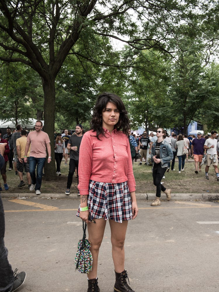 A woman in a pink cardigan an black-white checked shorts at the Pitchfork Music Festival